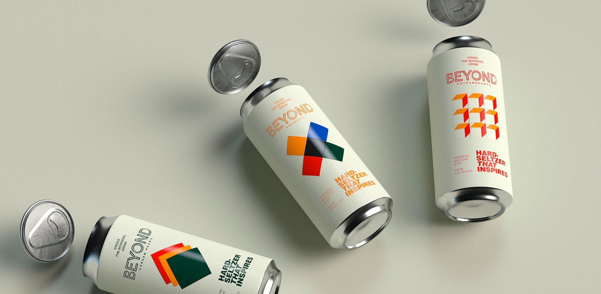 Drie kleine witte blikjes met kleurrijke etiketten en metalen dopjes liggen verspreid over een grijze ondergrond.