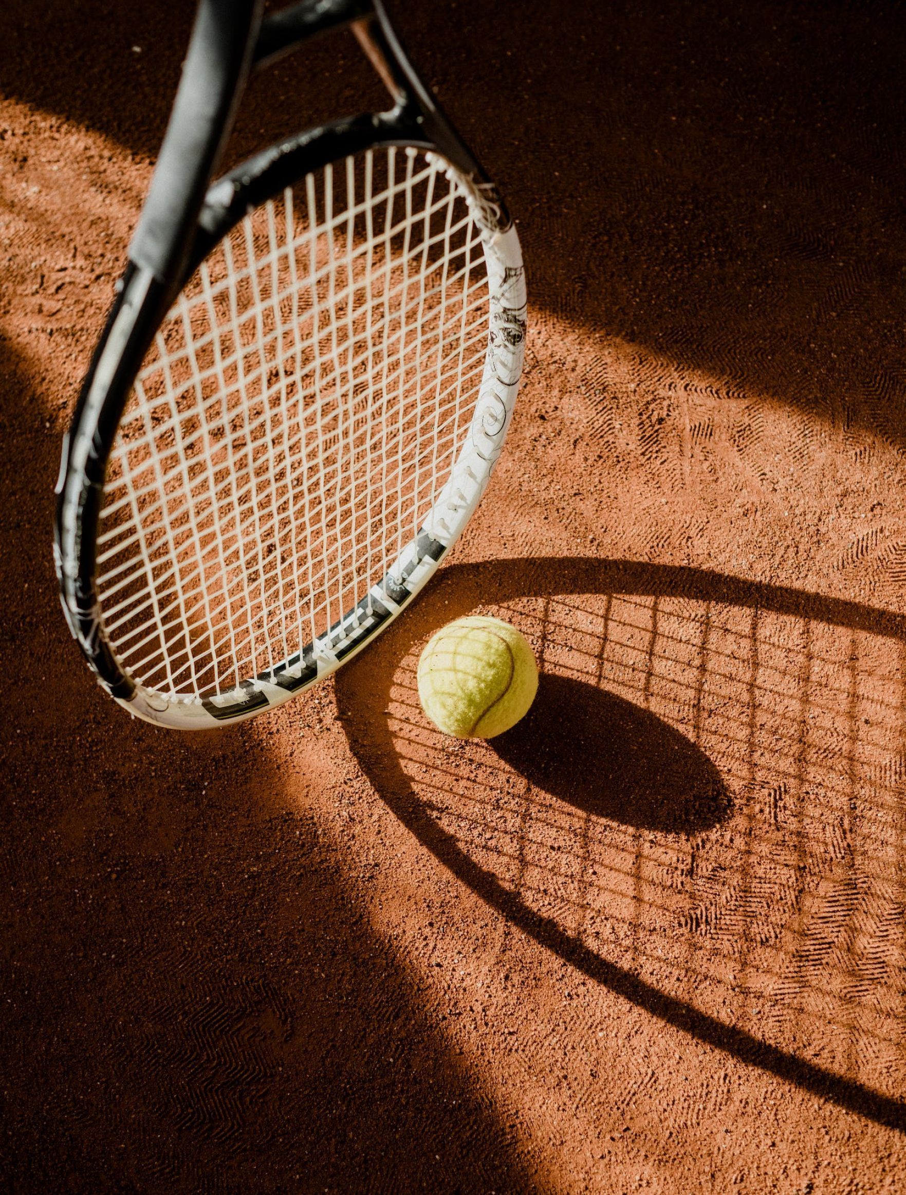 A tennis racket and ball on a tennis court