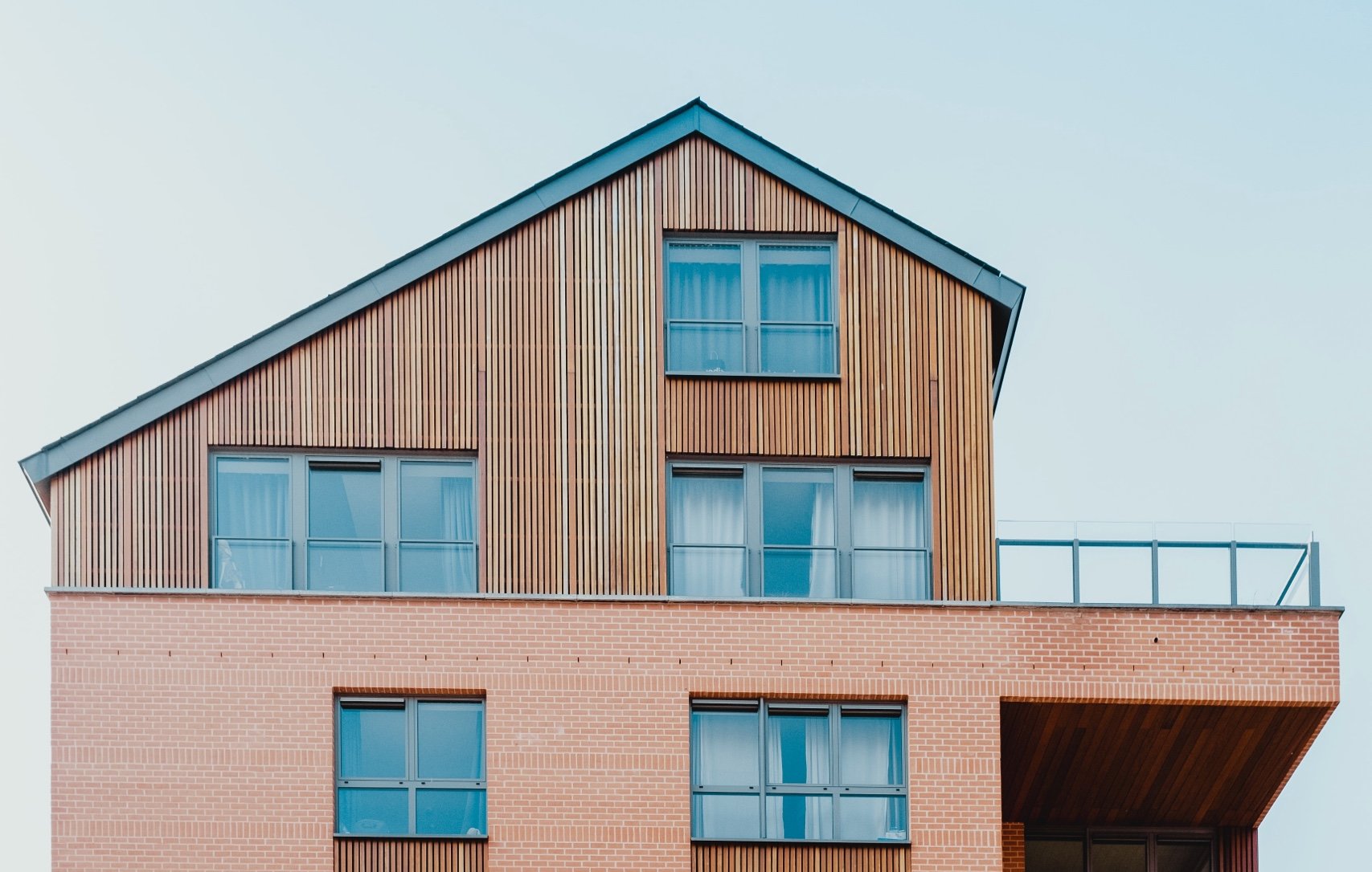 Una grande casa di mattoni con tetto in legno e balcone.