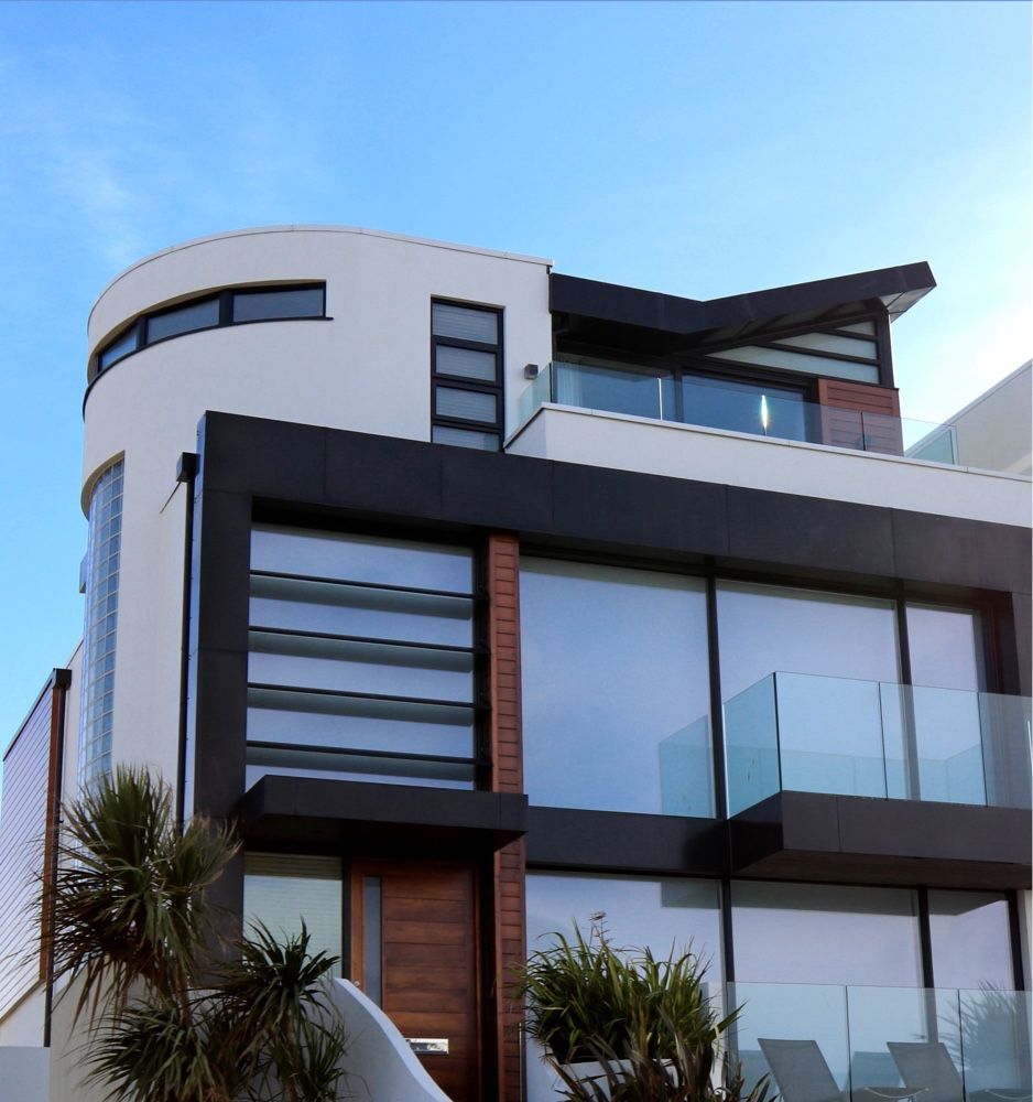 Une grande maison blanche et noire avec un balcon