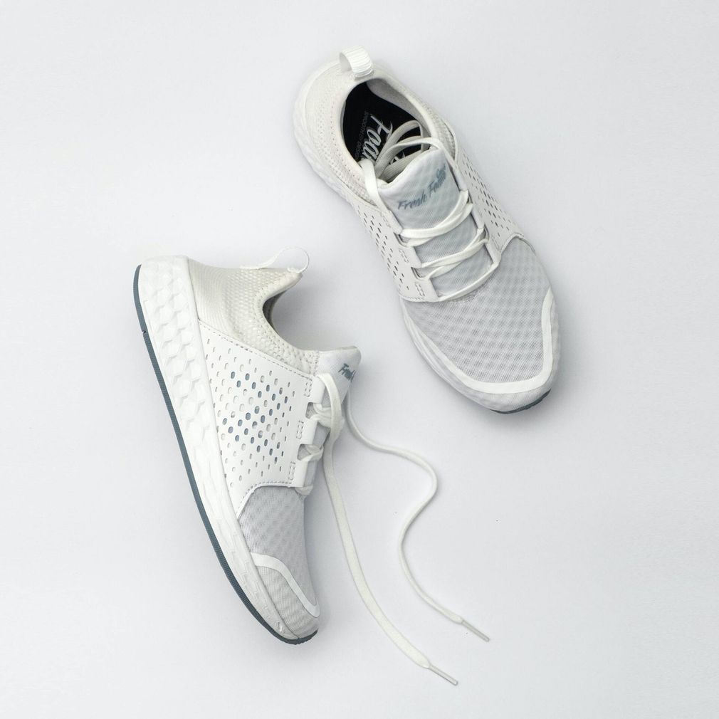 Pair of white athletic sneakers on a light gray background, shown from top and side views
