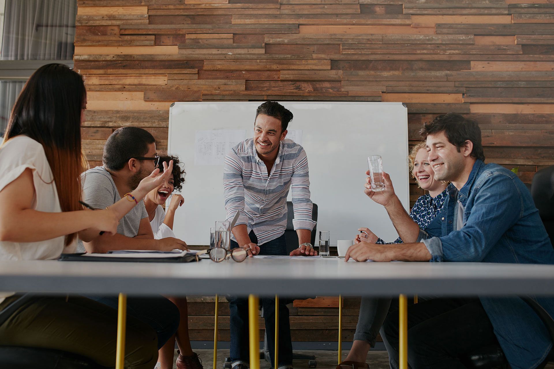 A group of people are sitting around a table having a meeting - Carmen & Co Consulting Strategic Consulting in Southeast Queensland