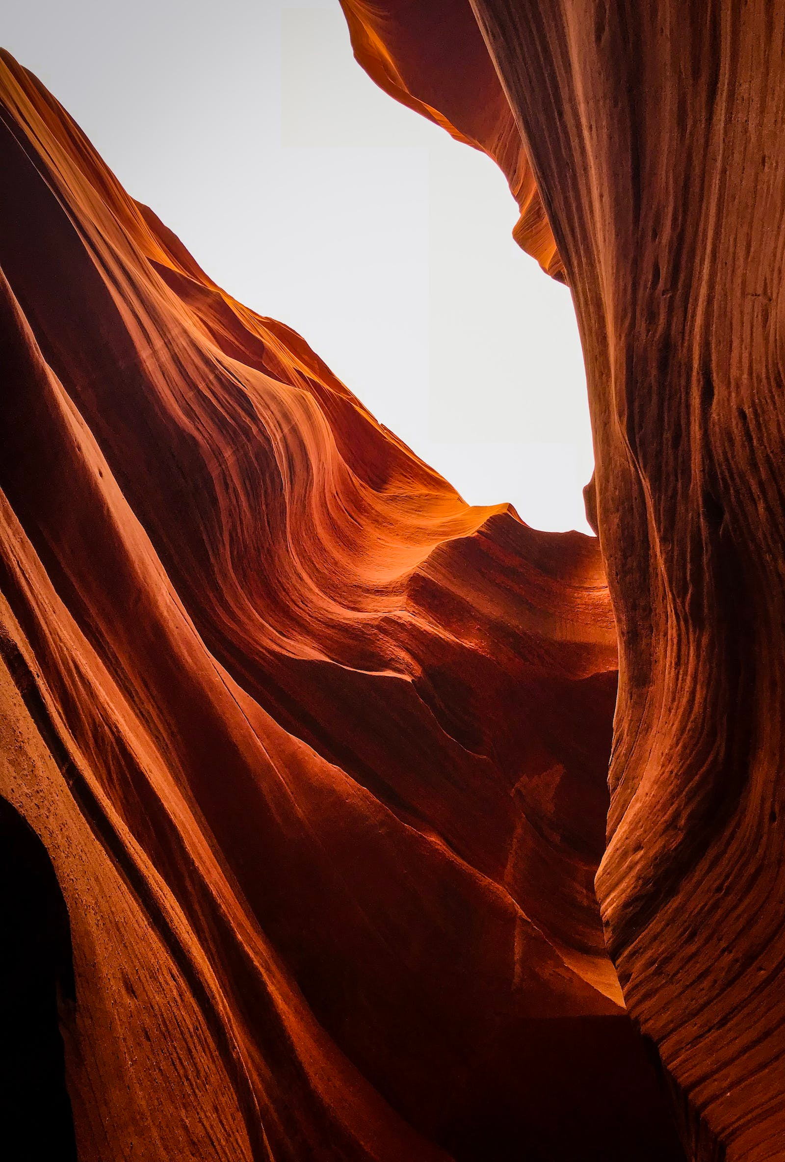 Sunlit red sandstone canyon walls with a narrow bright opening overhead