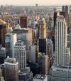 City skyline with various tall buildings under a hazy sky.