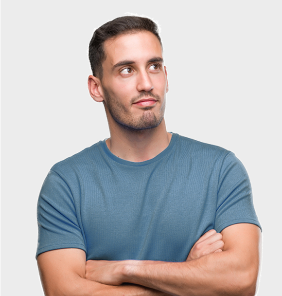 Man in a blue shirt with arms crossed, looking to the side against a light gray background