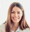 A woman with long hair is smiling for the camera.