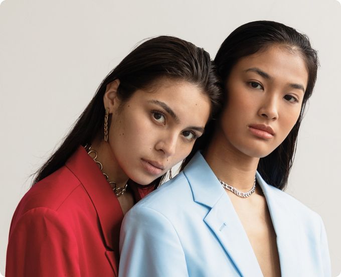 Twee vrouwen poseren samen voor een foto. De een draagt een rood jasje en de ander een blauw jasje.