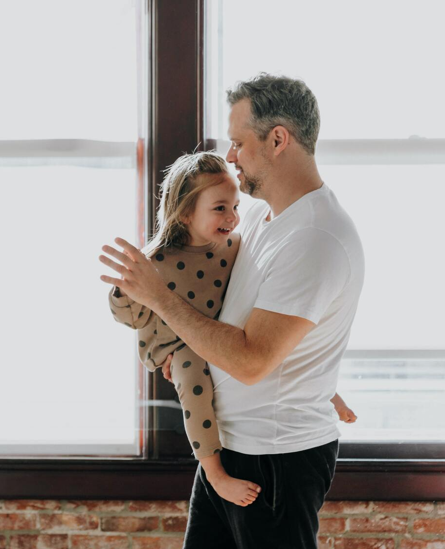 A man is holding a little girl in his arms.