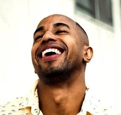 A man with a beard is laughing with his mouth open