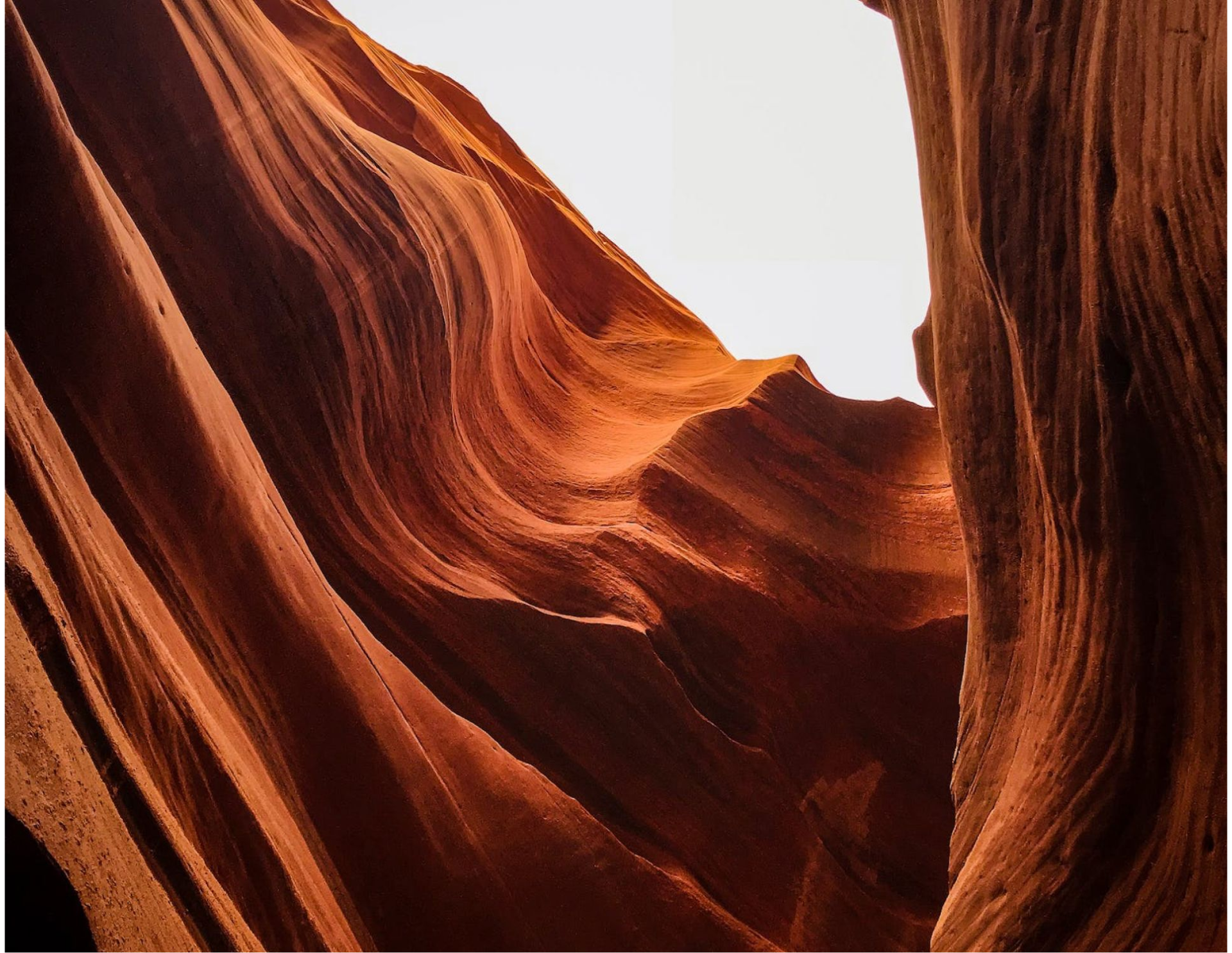 Red-orange sandstone canyon walls with a narrow opening to bright sky above