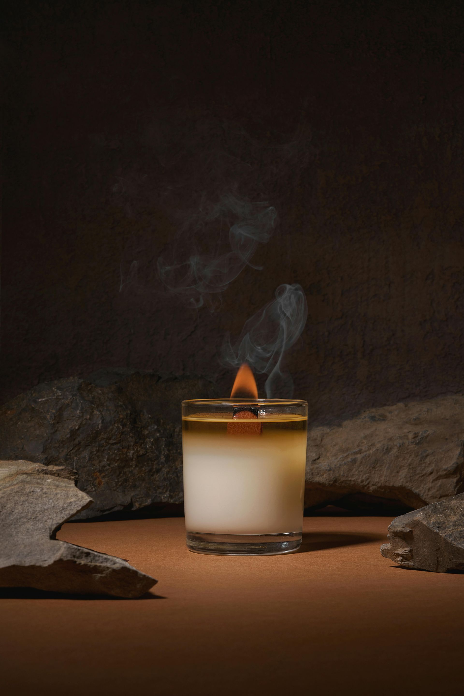 A close up of a candle in a glass on a table.