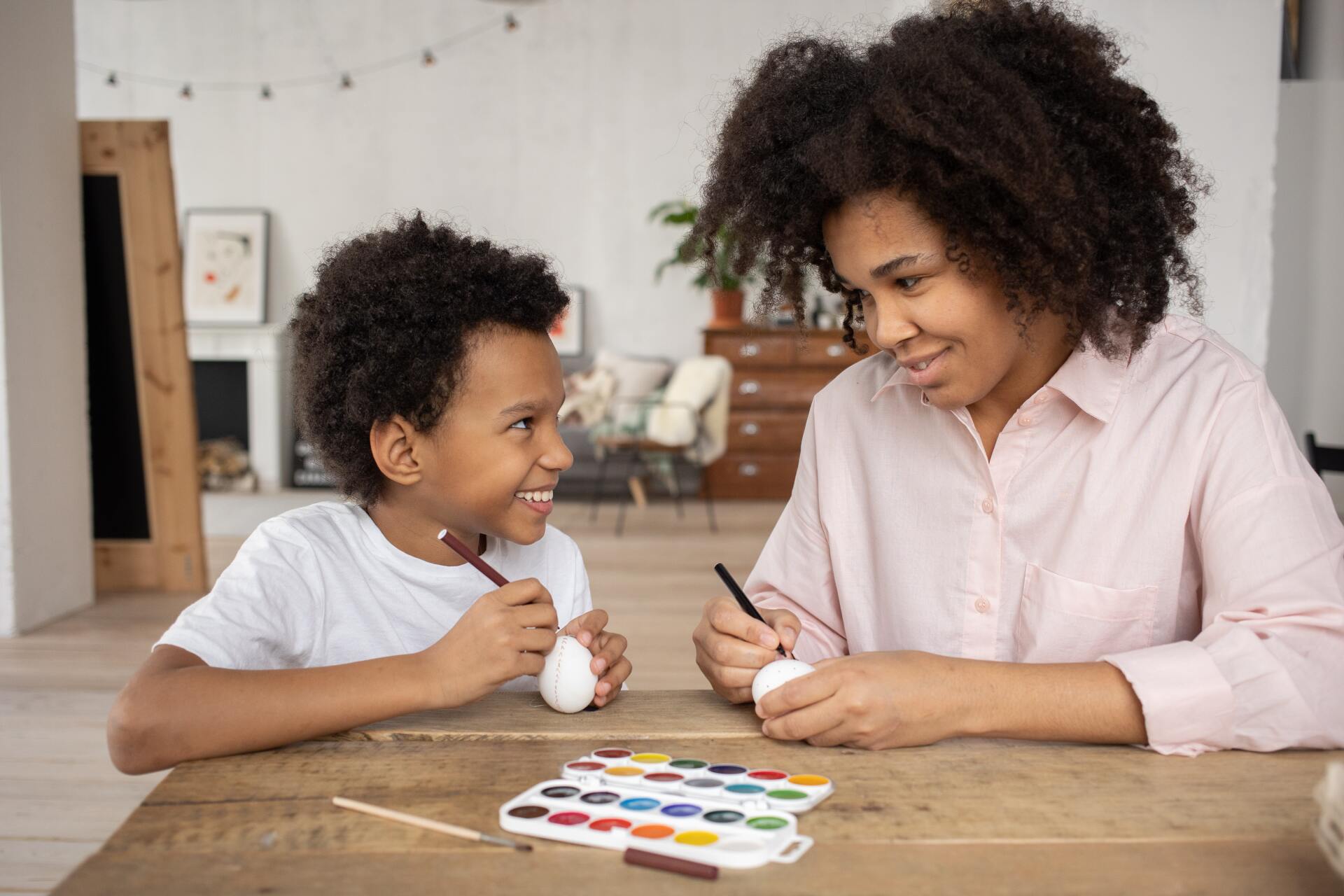 Young boy interacting with his Mother and paints