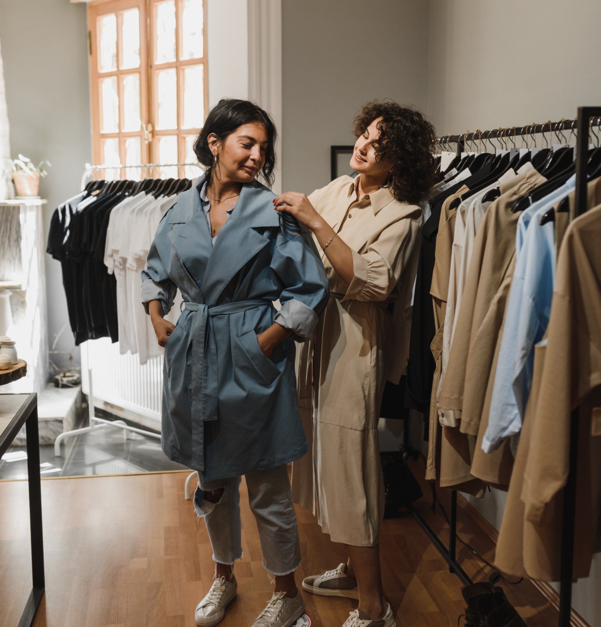 Two women are trying on clothes in a store.