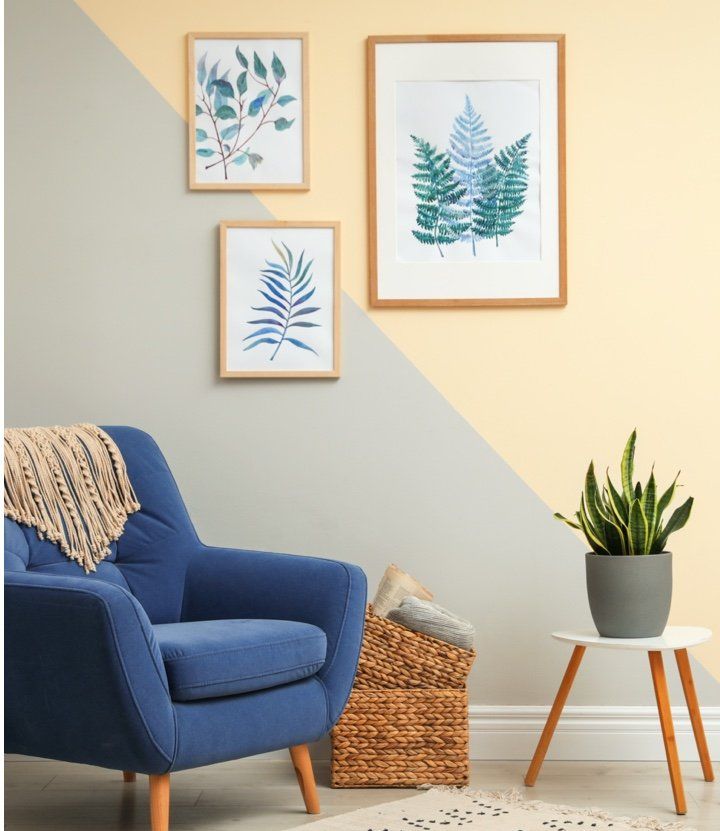 A living room with a blue chair and a potted plant