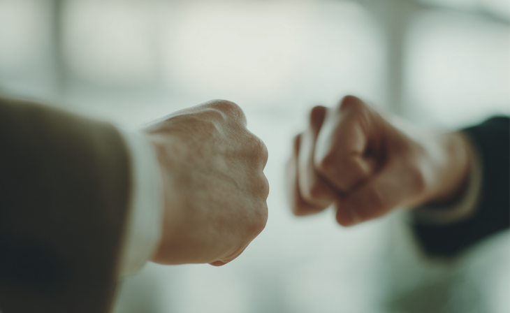 Two fists meeting in a fist bump against a blurred background