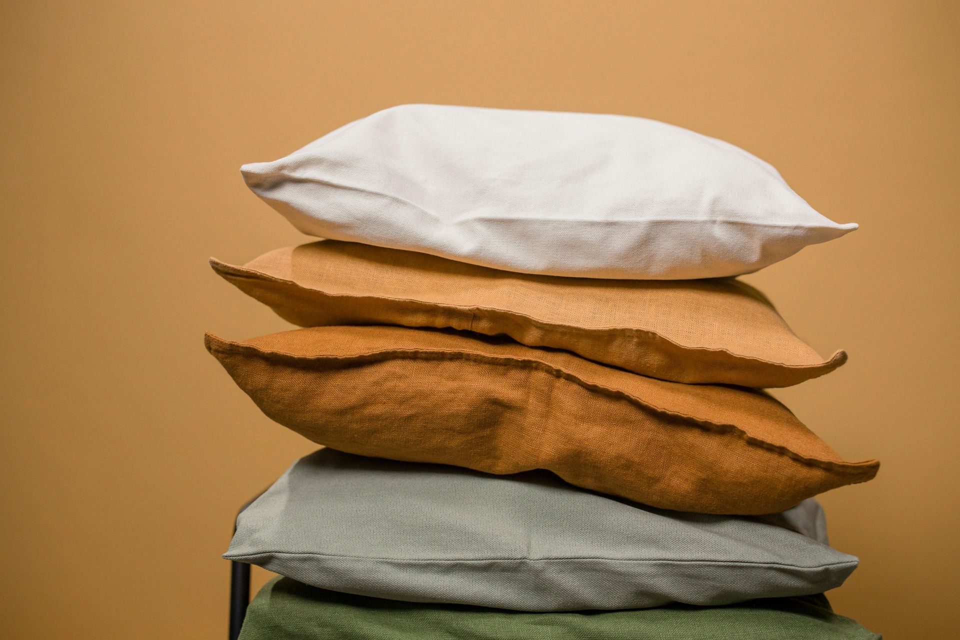 A pile of pillows stacked on top of each other on a table.