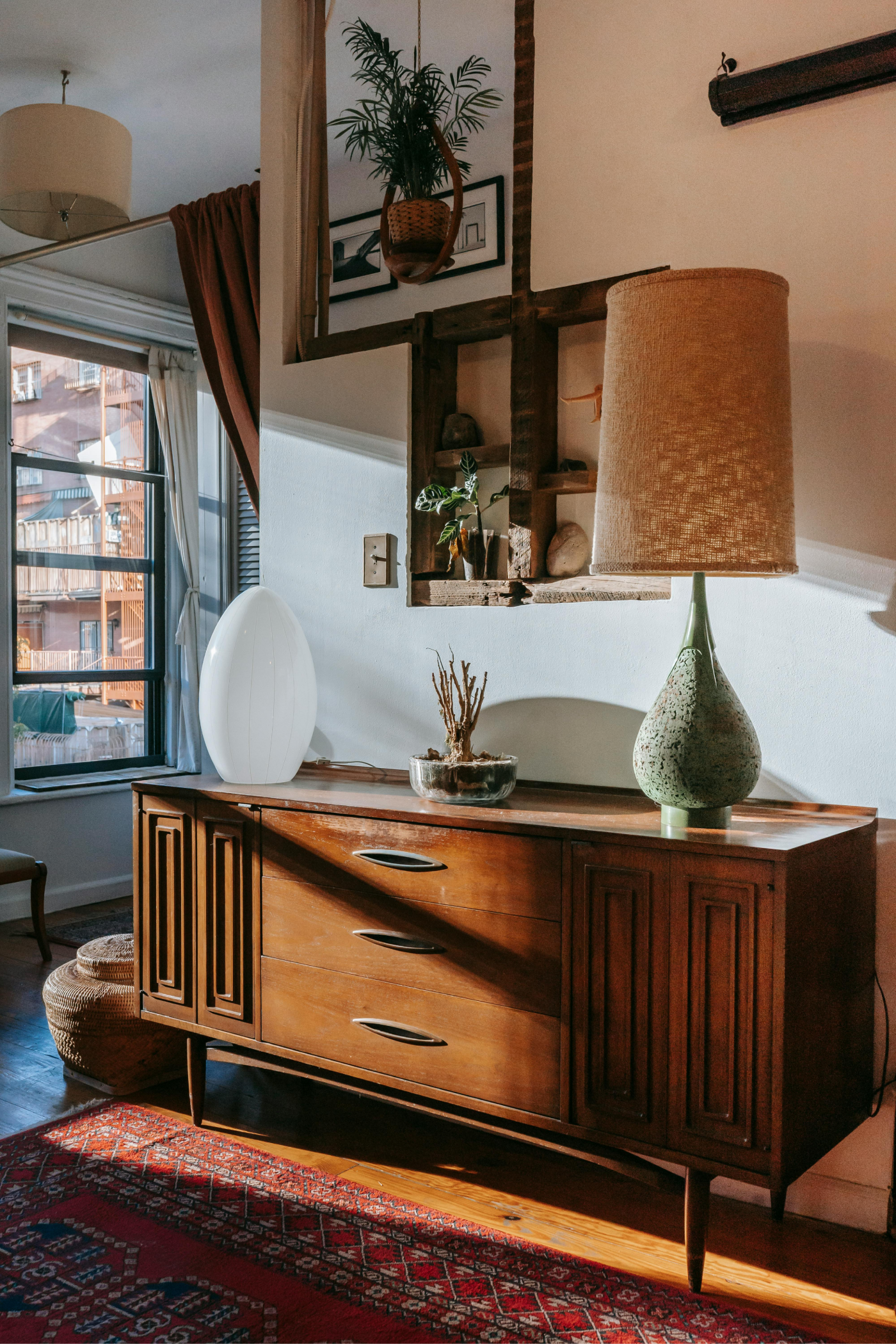 Un salon avec une commode en bois et une lampe.