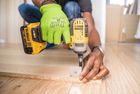 Workman using drill on flooring during installation