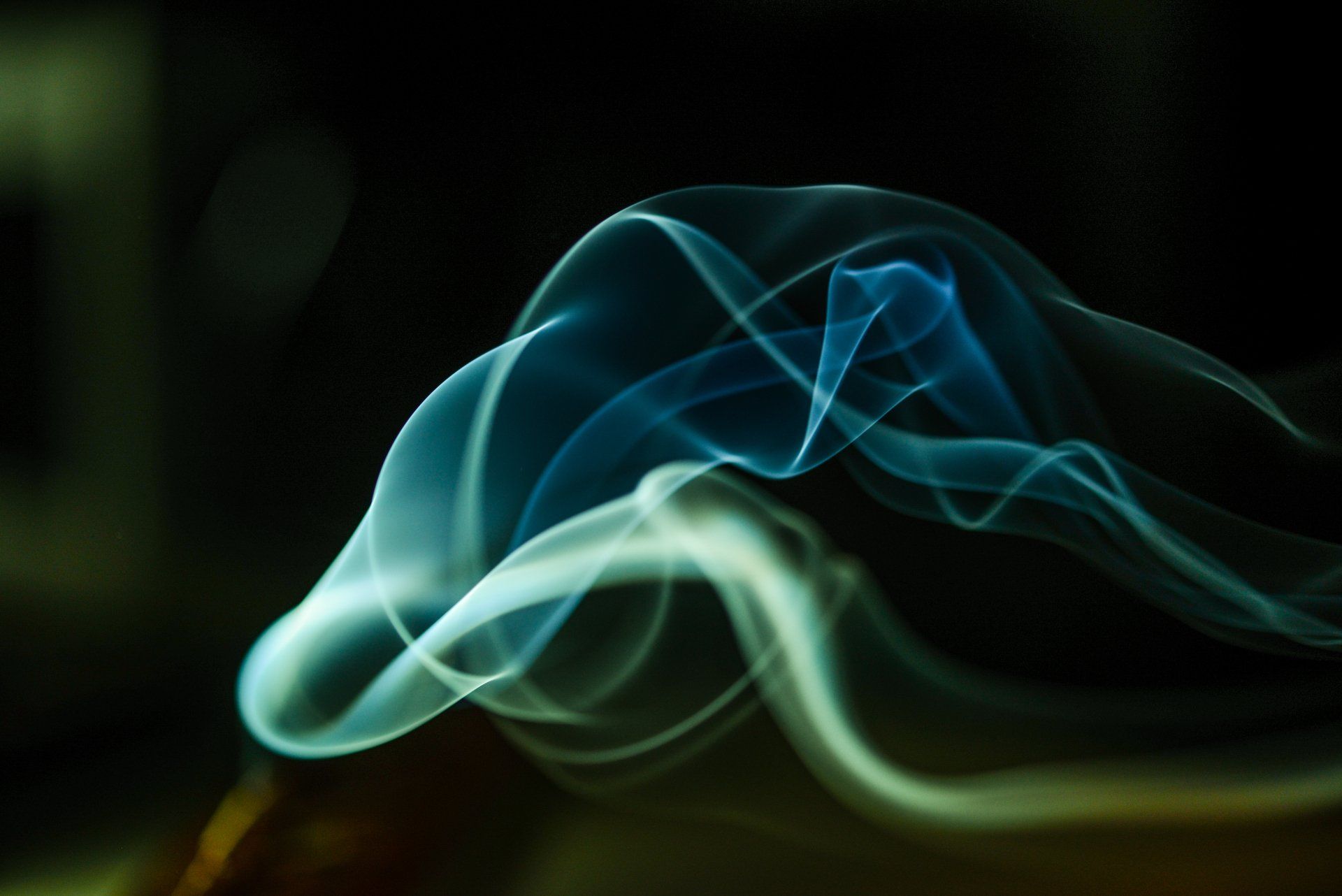 A close up of blue smoke on a black background.