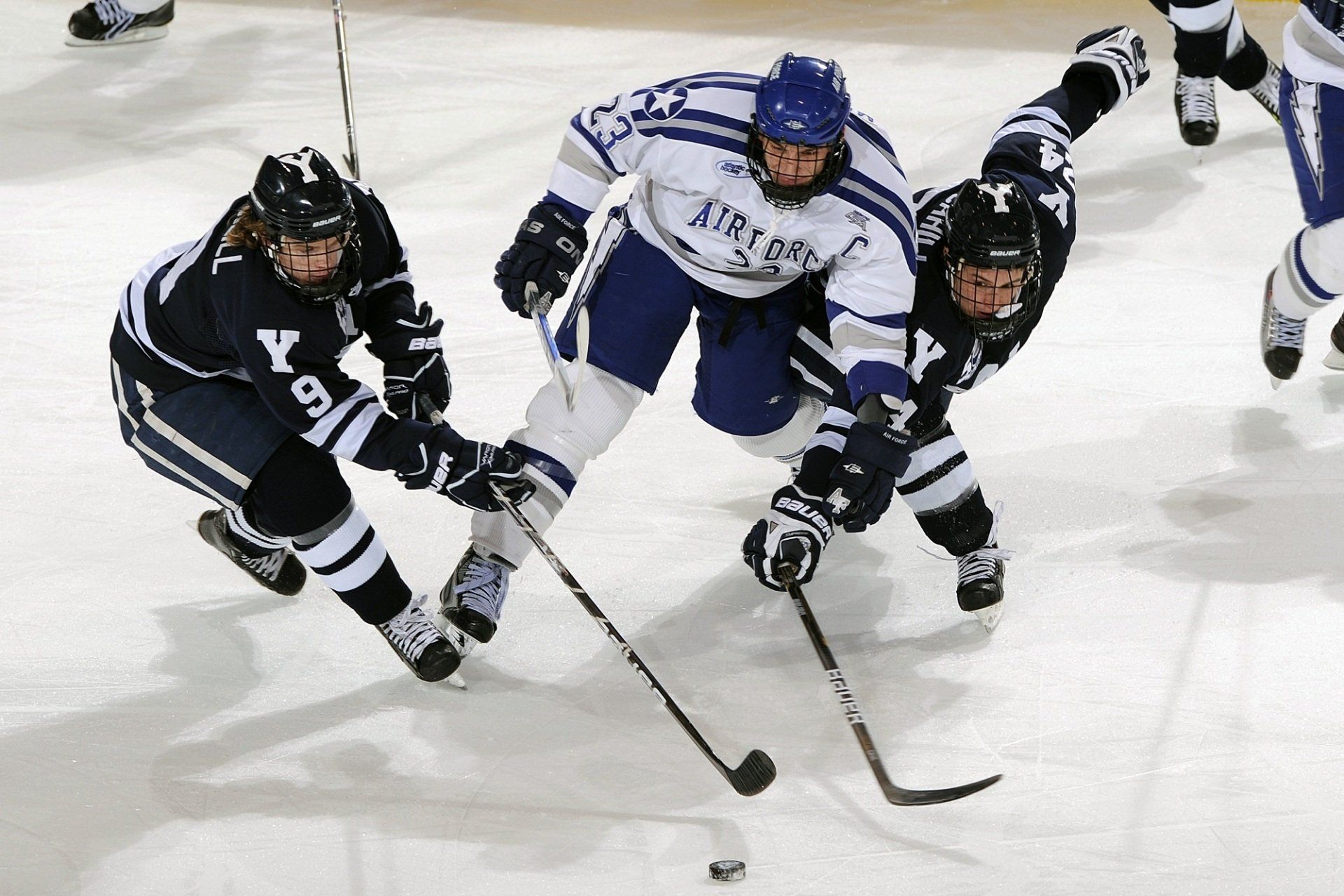 A hockey player wearing a jersey that says ' air force ' on it