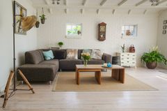 A living room with a couch , two coffee tables , and a clock on the wall.