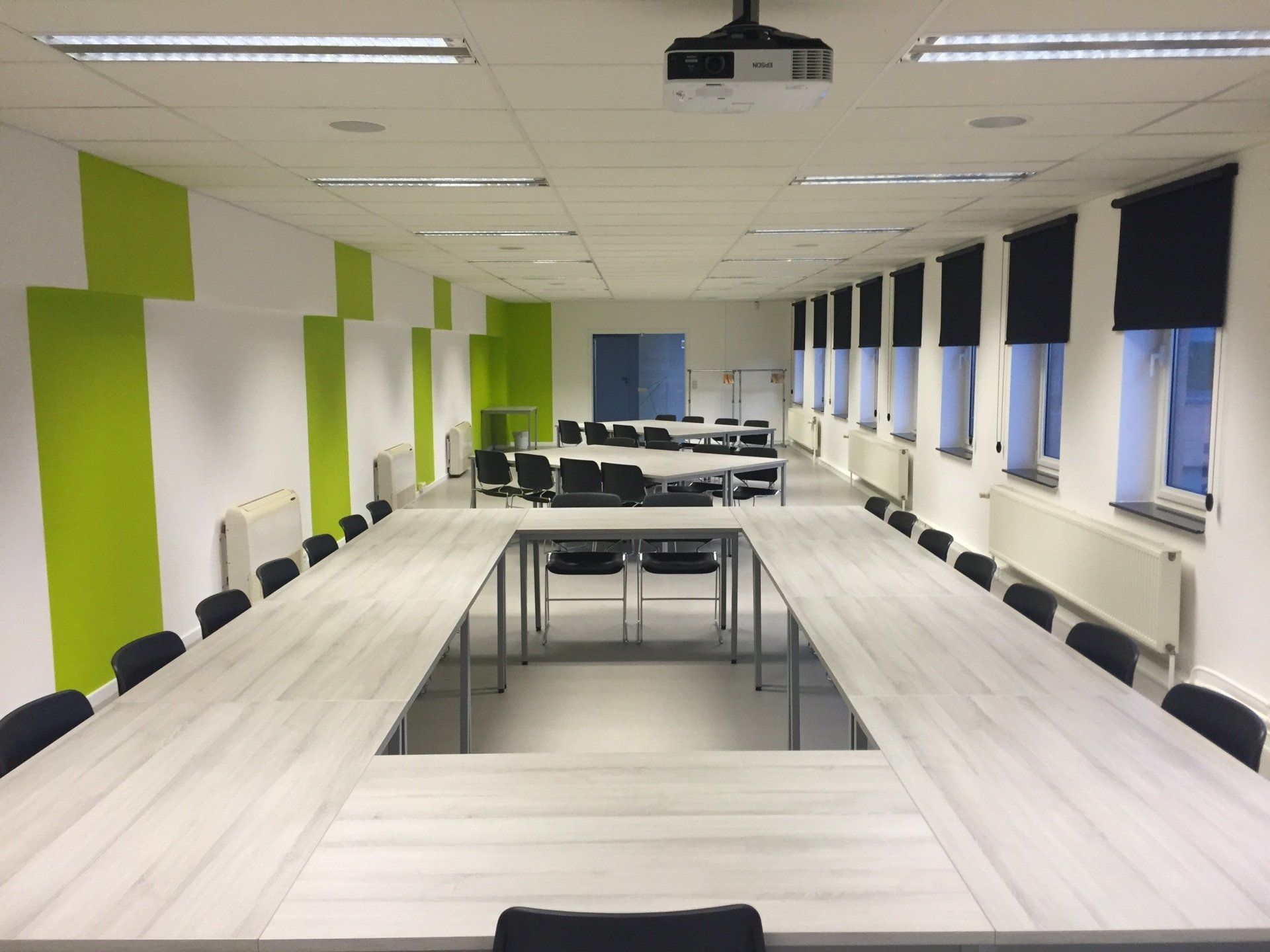 Modern eco style meeting room with big wooden table, white chairs around, parquet