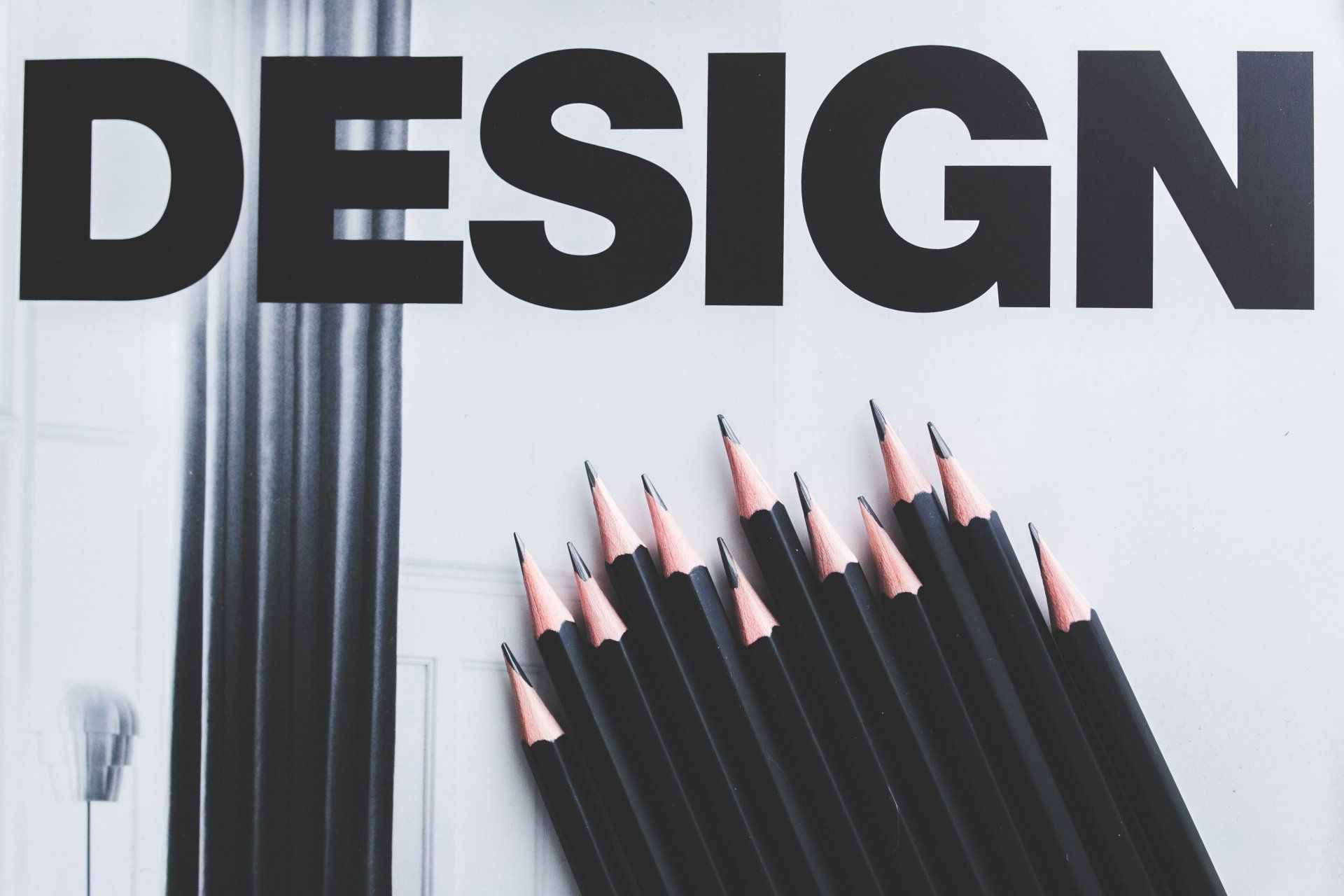 a bunch of pencils are sitting on top of a piece of paper that says design