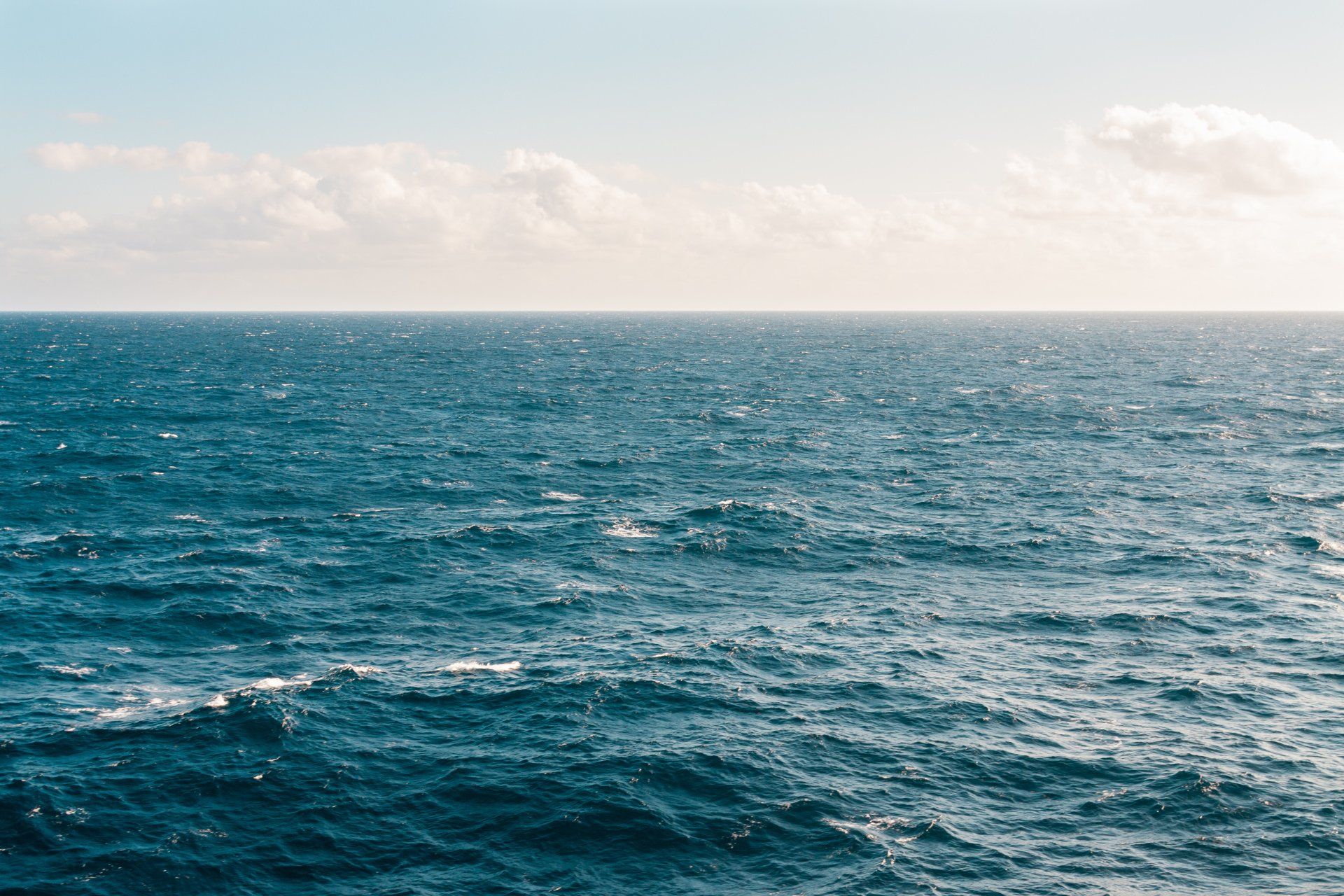 Elemanta Boutique Hotel | Blue sea with gentle waves beneath a cloudy sky