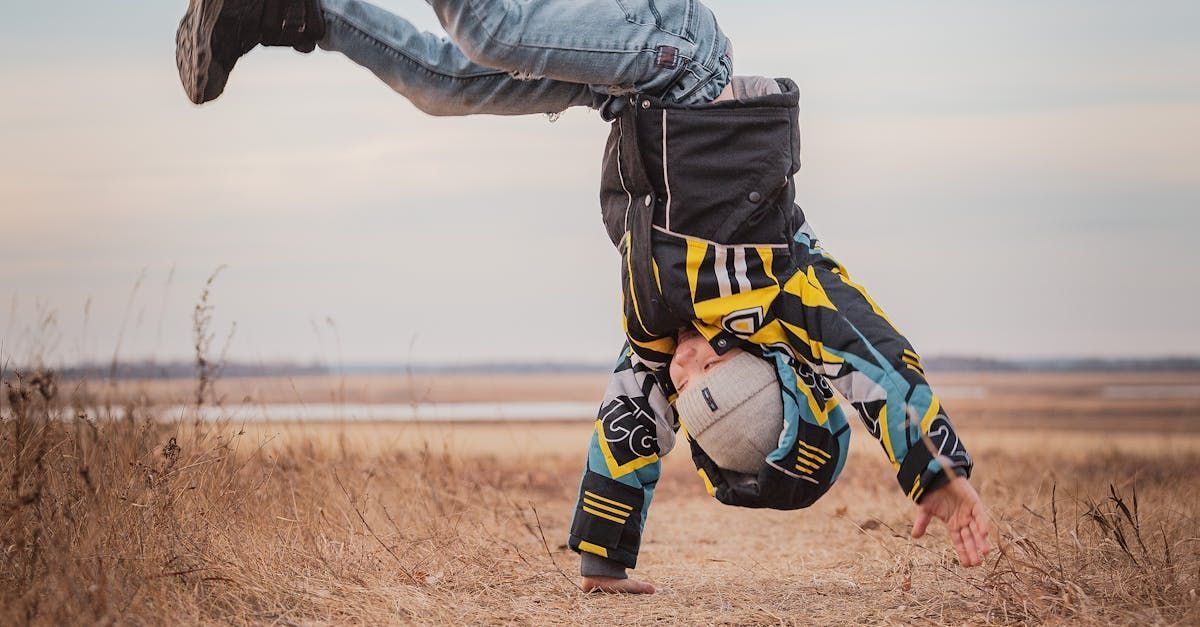 A person is doing a handstand in a field.