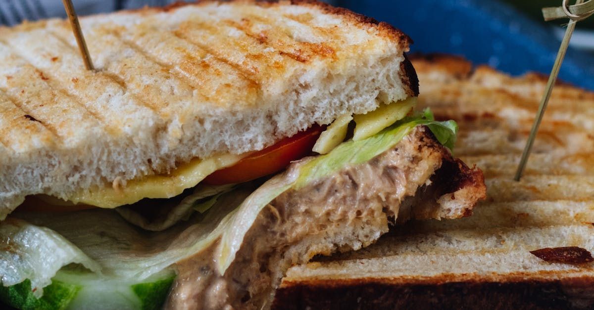 A close up of a sandwich on a plate with toothpicks in it.