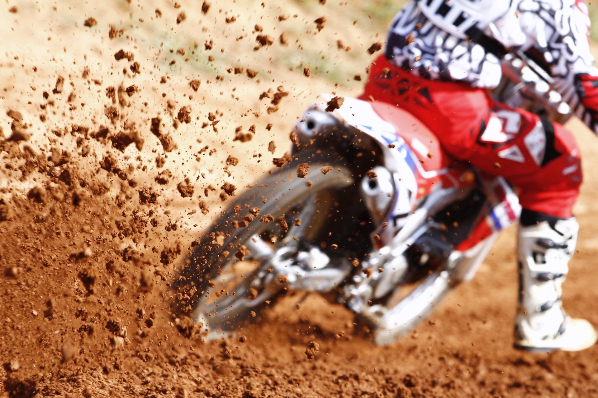 A person is riding a dirt bike on a dirt track.