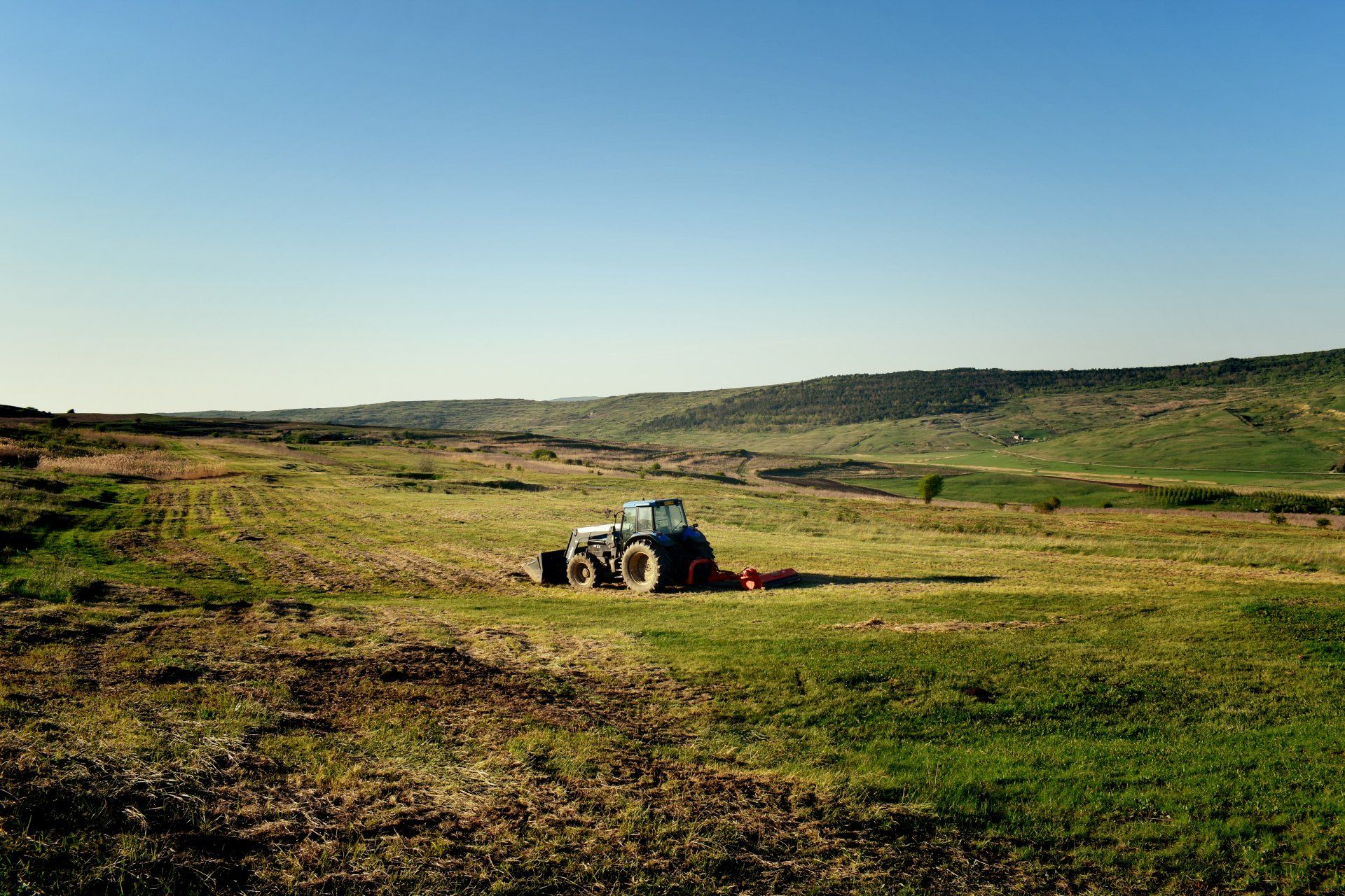 A tractor is sitting in the middle of a grassy field.