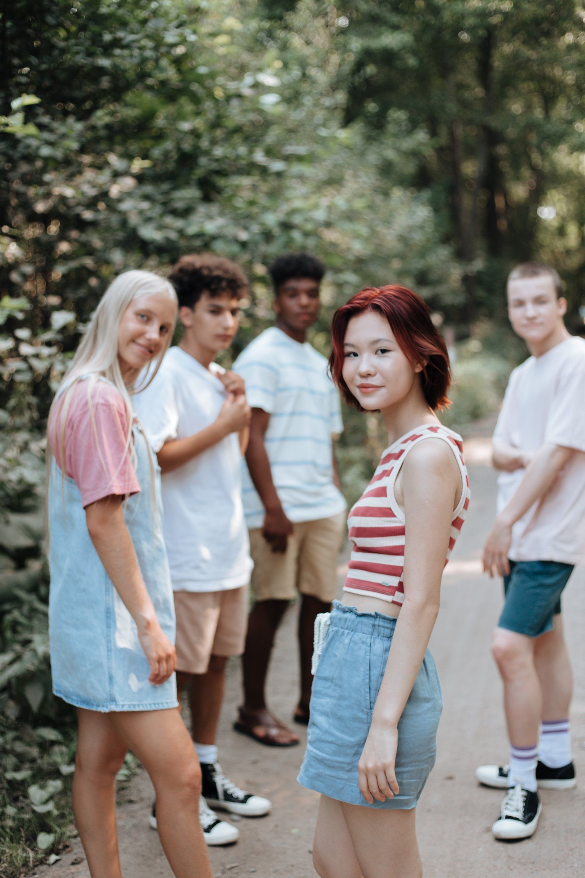 Een groep jongeren staat naast elkaar op een pad in het bos. zelfvetrouwen