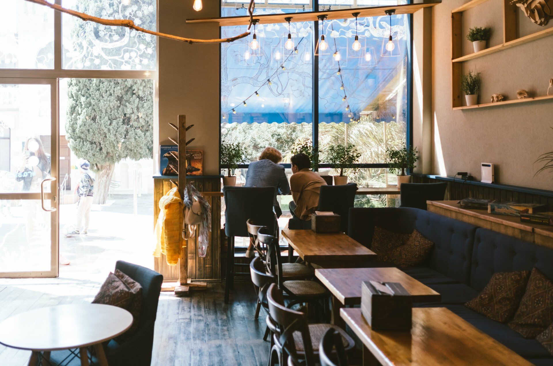 A group of people are sitting at tables in a restaurant.