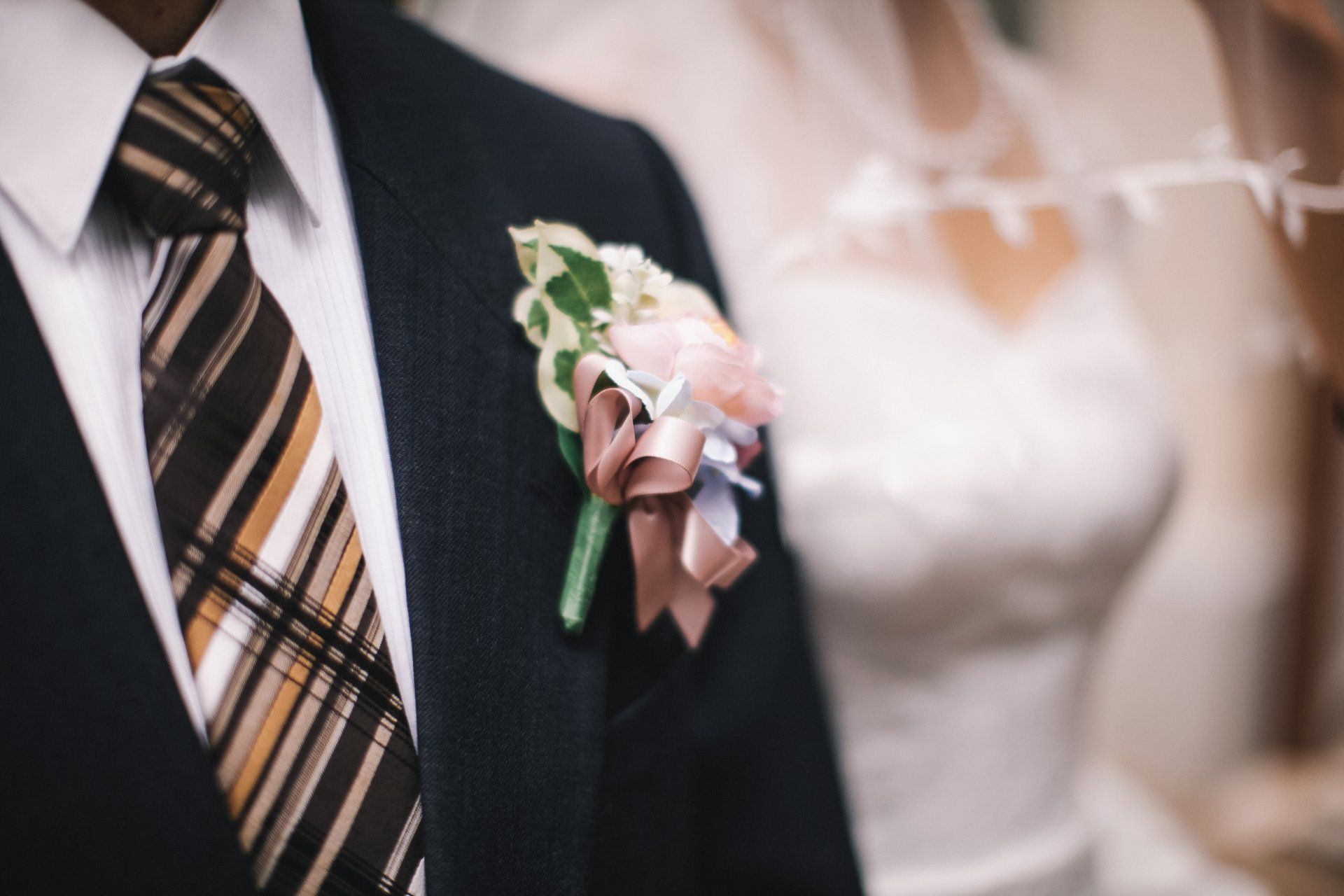 Een man in een pak draagt een corsage in zijn pochet