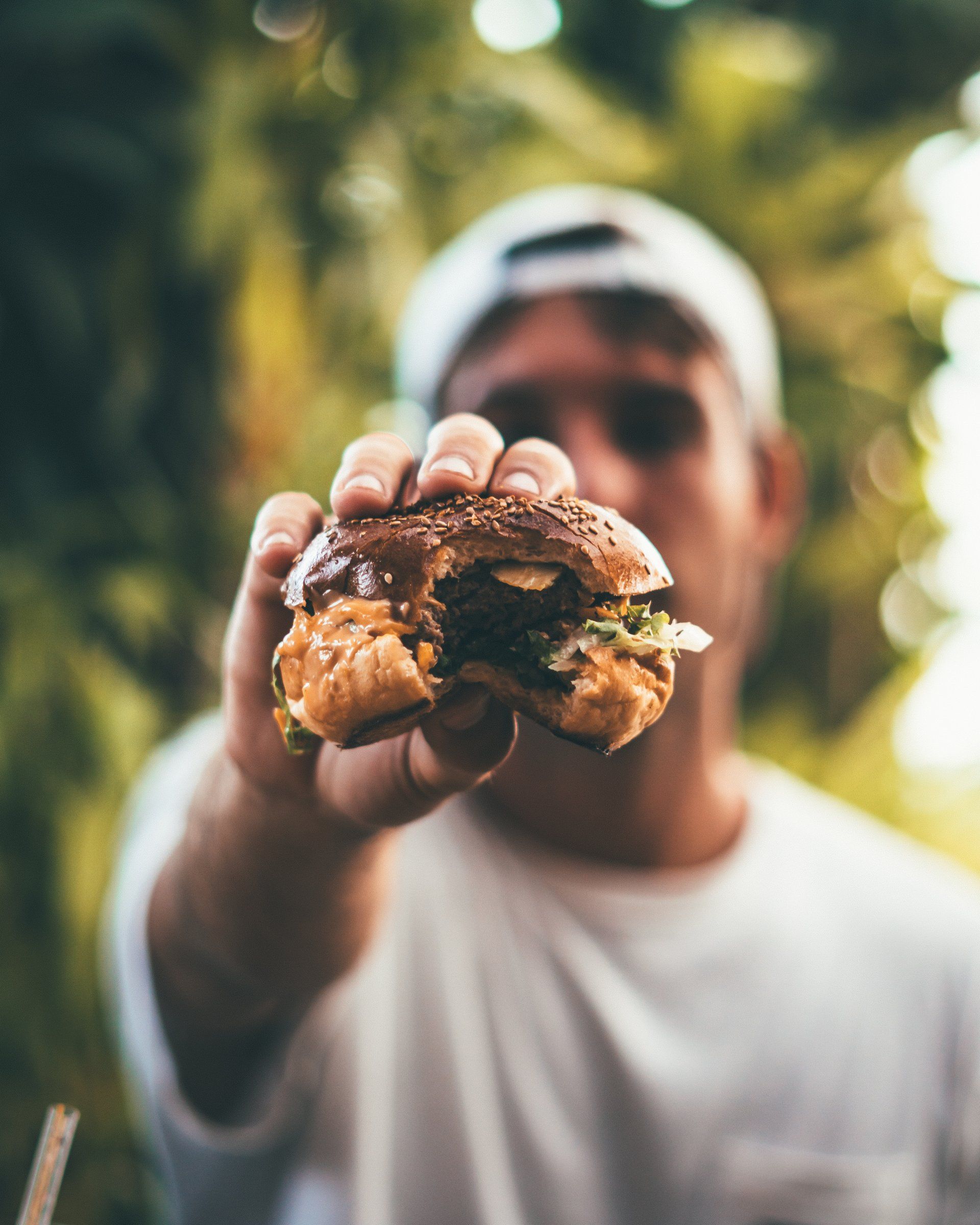A man is holding a half eaten hamburger in his hand