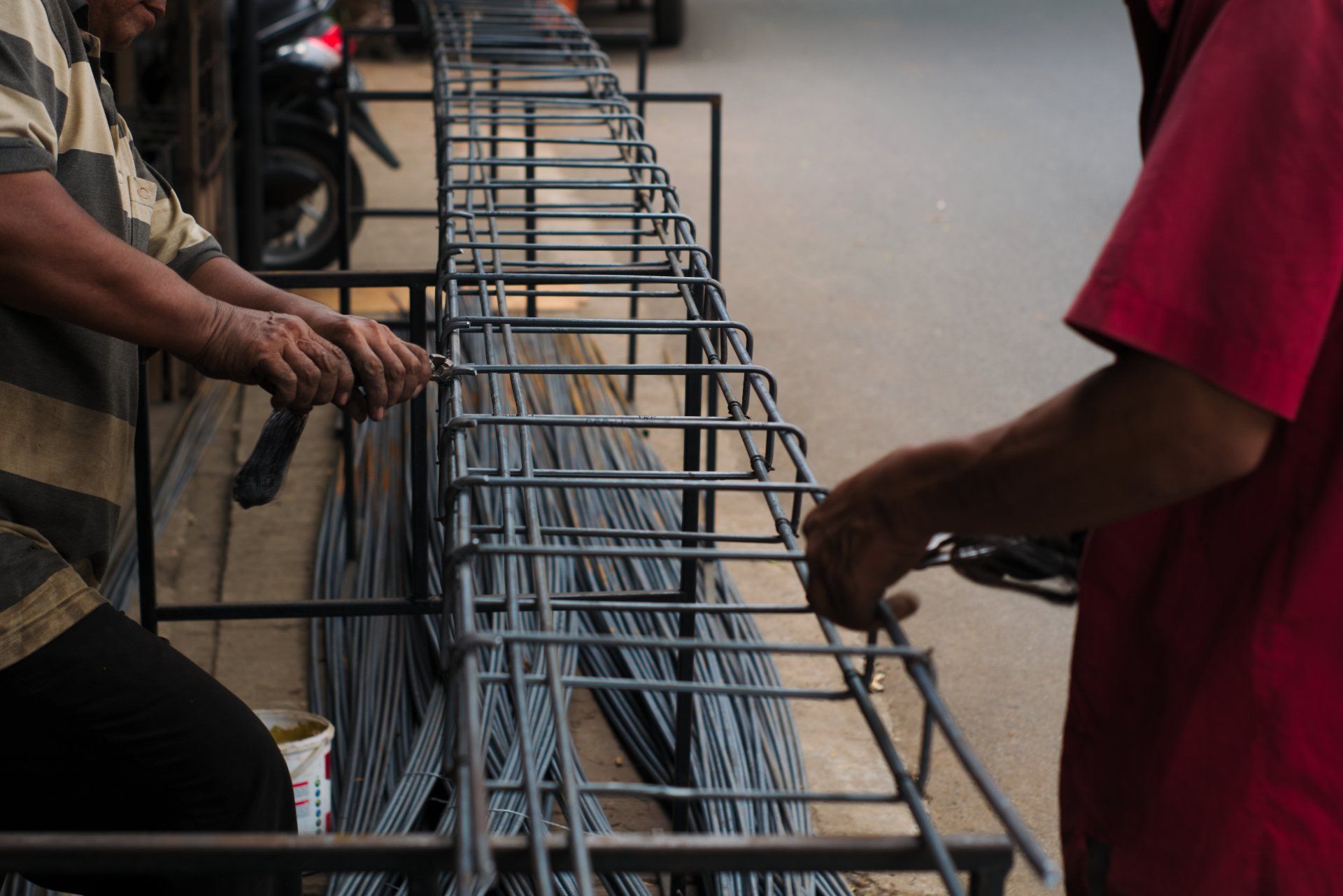 Workers tying steel rebar cages for concrete reinforcement on a construction jobsite