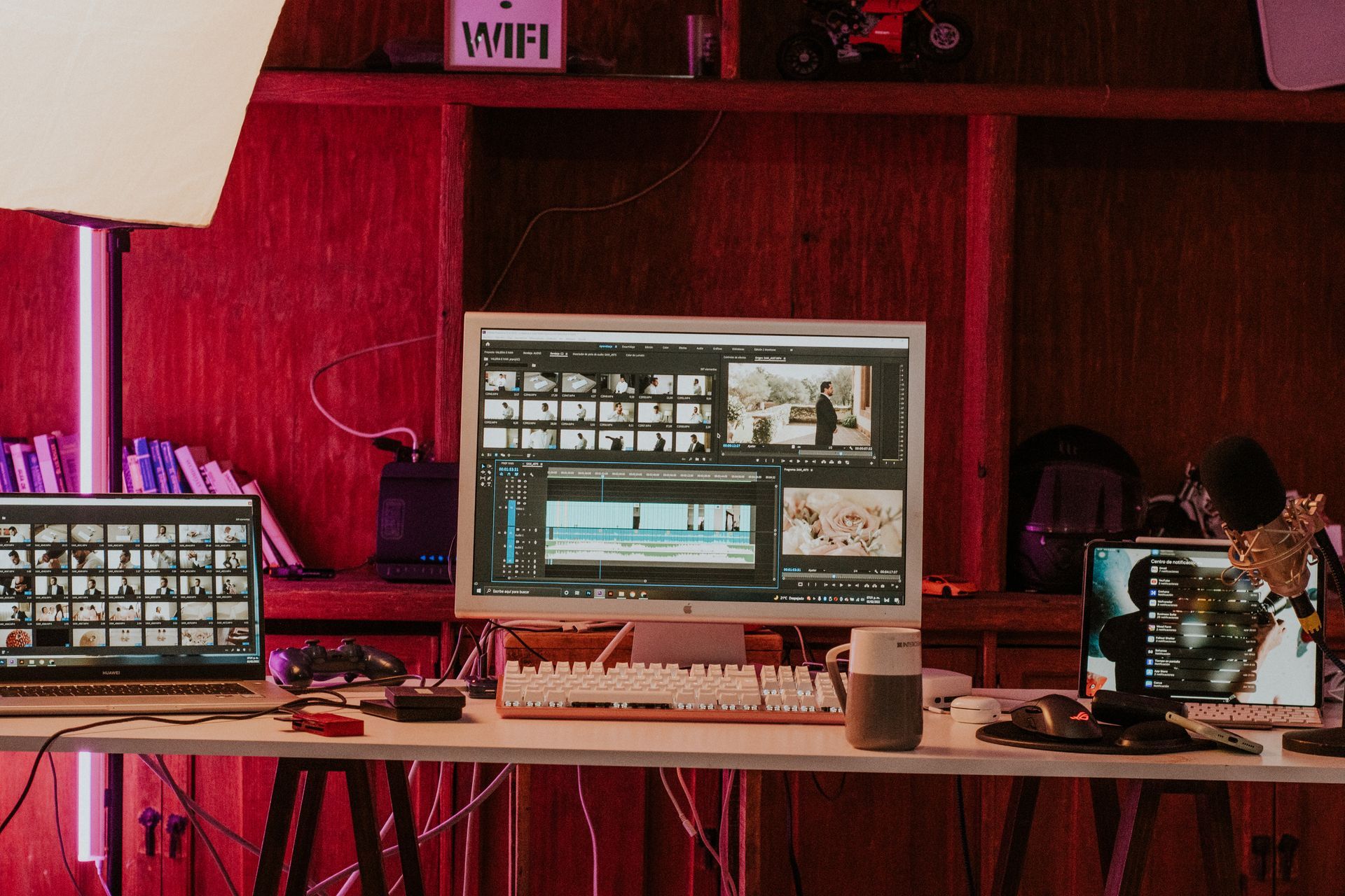 A computer monitor is sitting on top of a wooden desk next to a laptop.