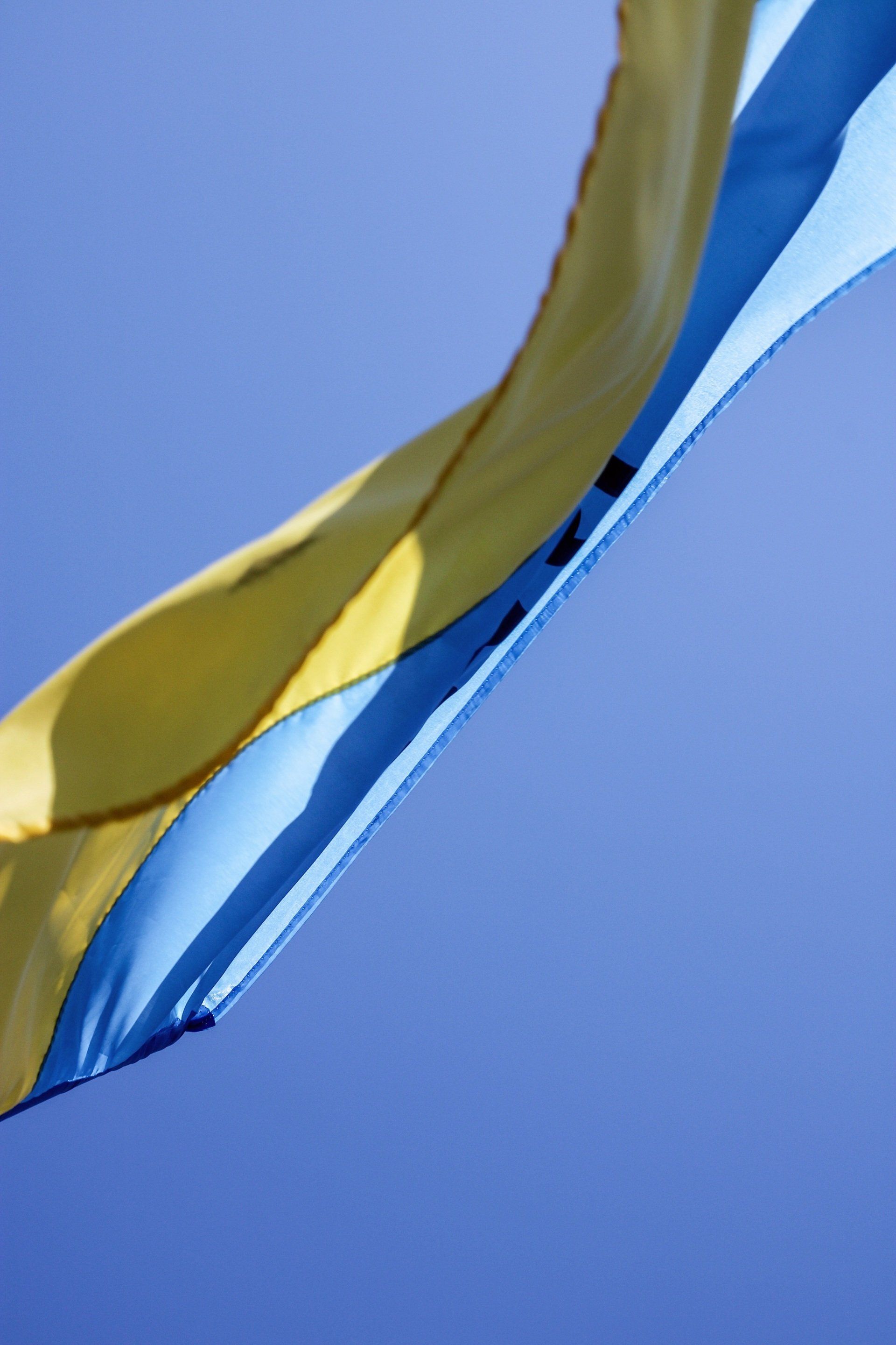 A yellow and blue flag is flying in the wind