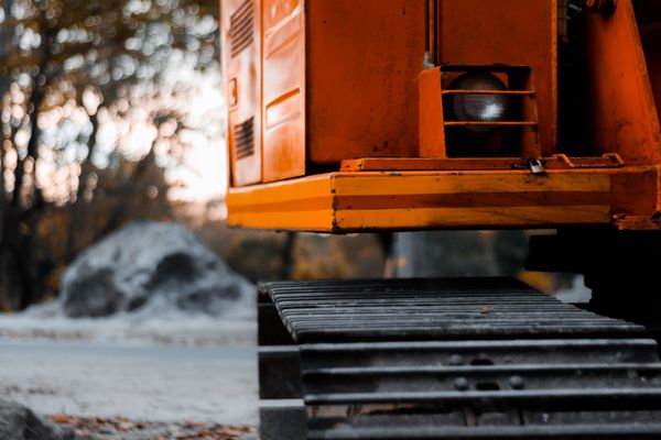 Orange tracked vehicle wheel on snowy ground at sunset