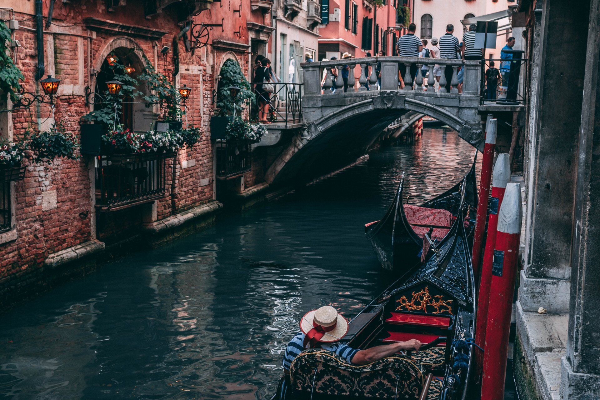 A woman is sitting in a gondola on a canal in venice.