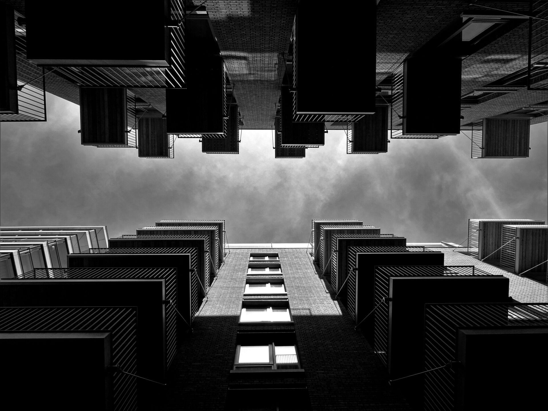 A black and white photo of a building looking up at the sky