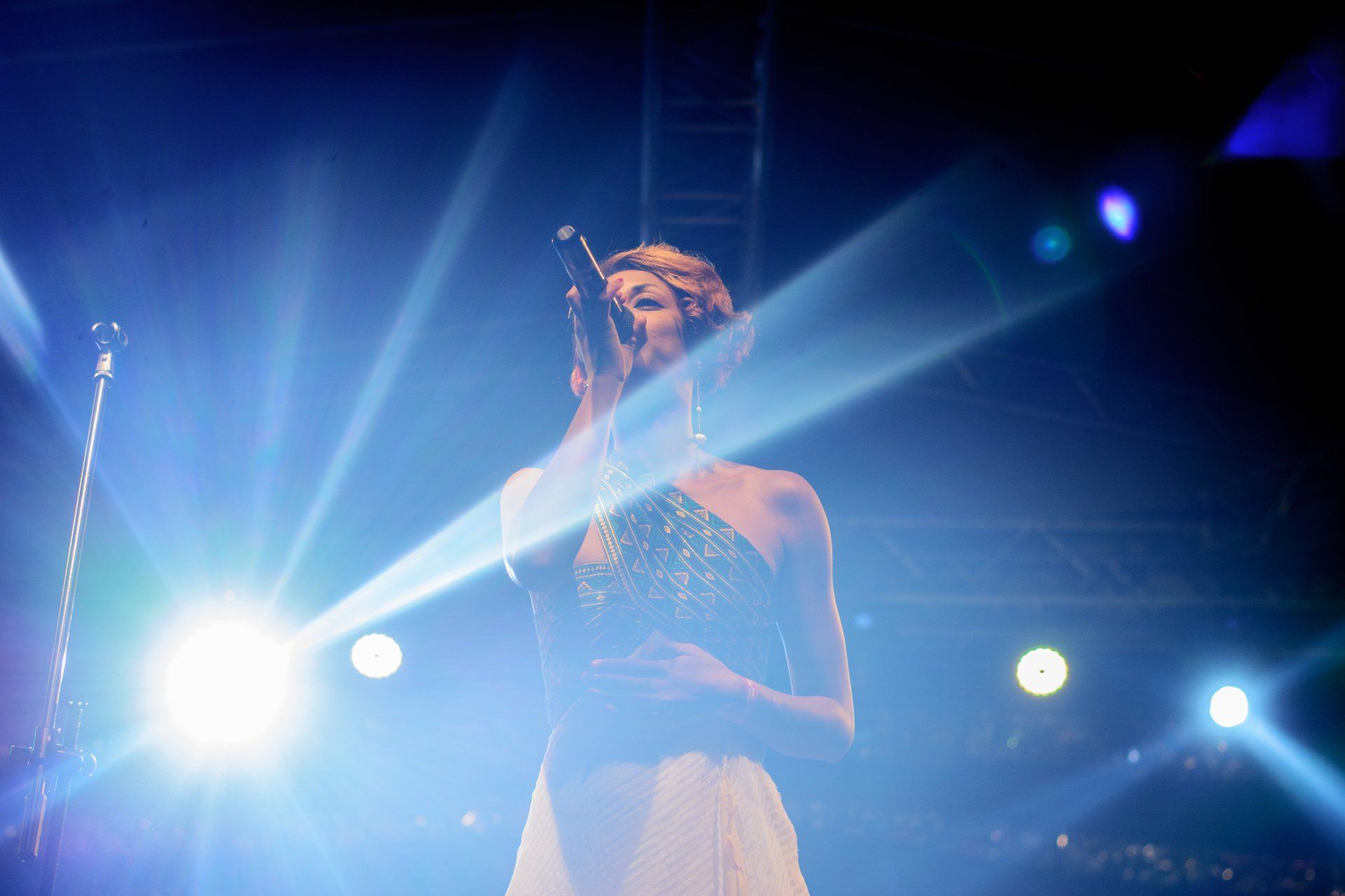 Music performer on stage under bright spotlights during a live show