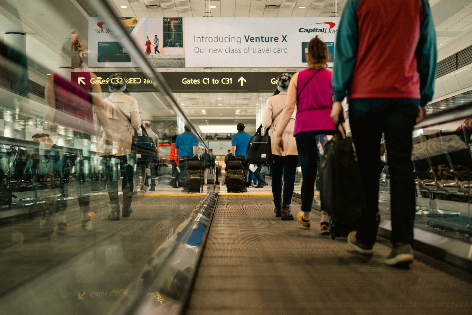 Travelers walking through an airport concourse