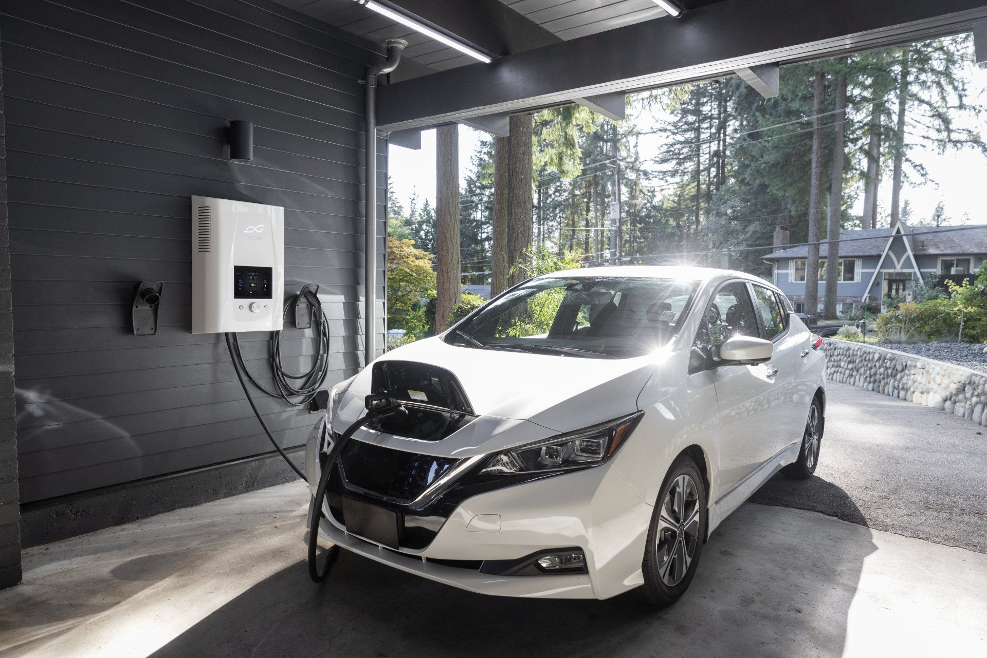 A white electric car is being charged in a garage.