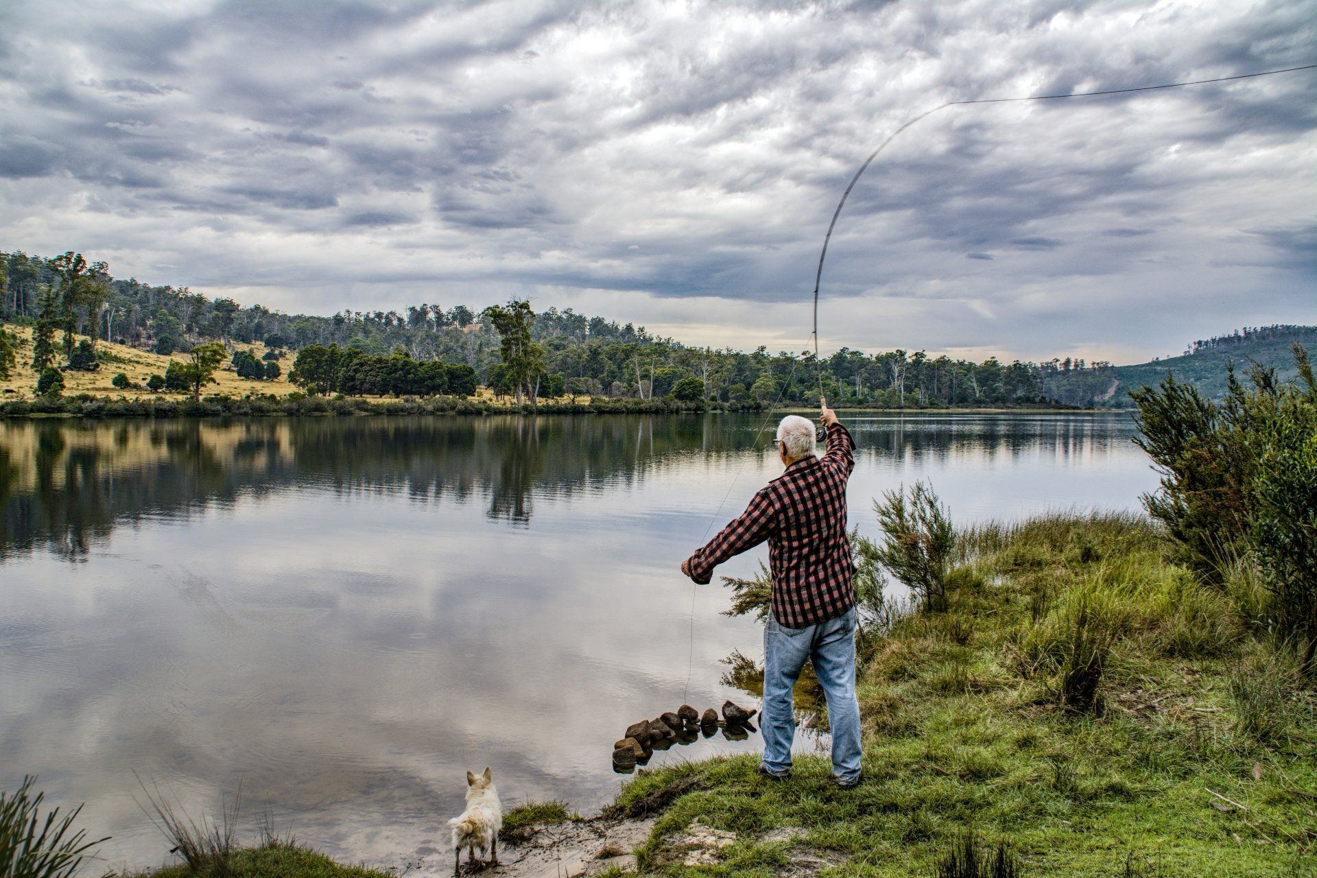 Man fishing in Clear Creek with mountains in the background