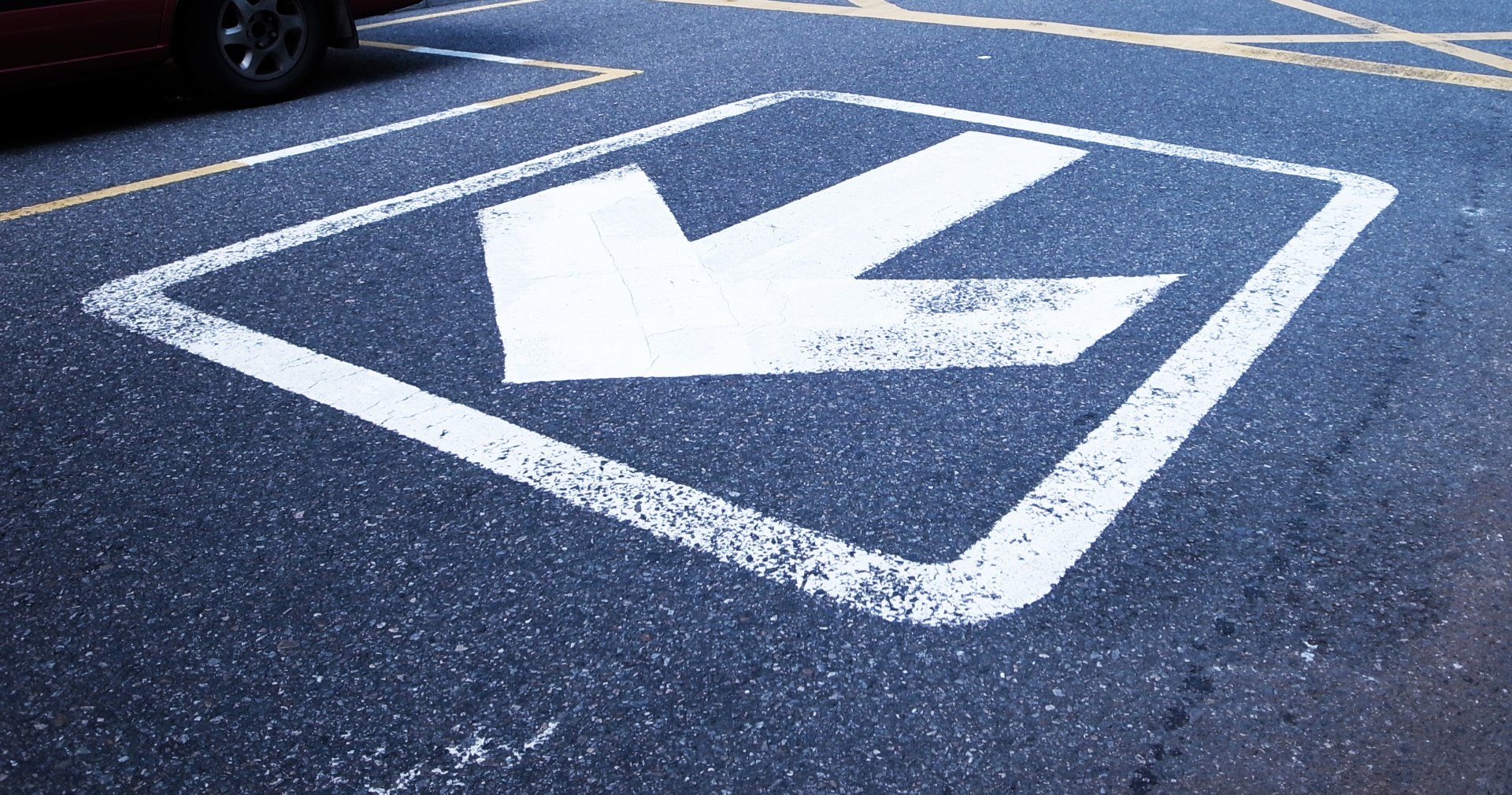 A white arrow is painted on the side of a road.