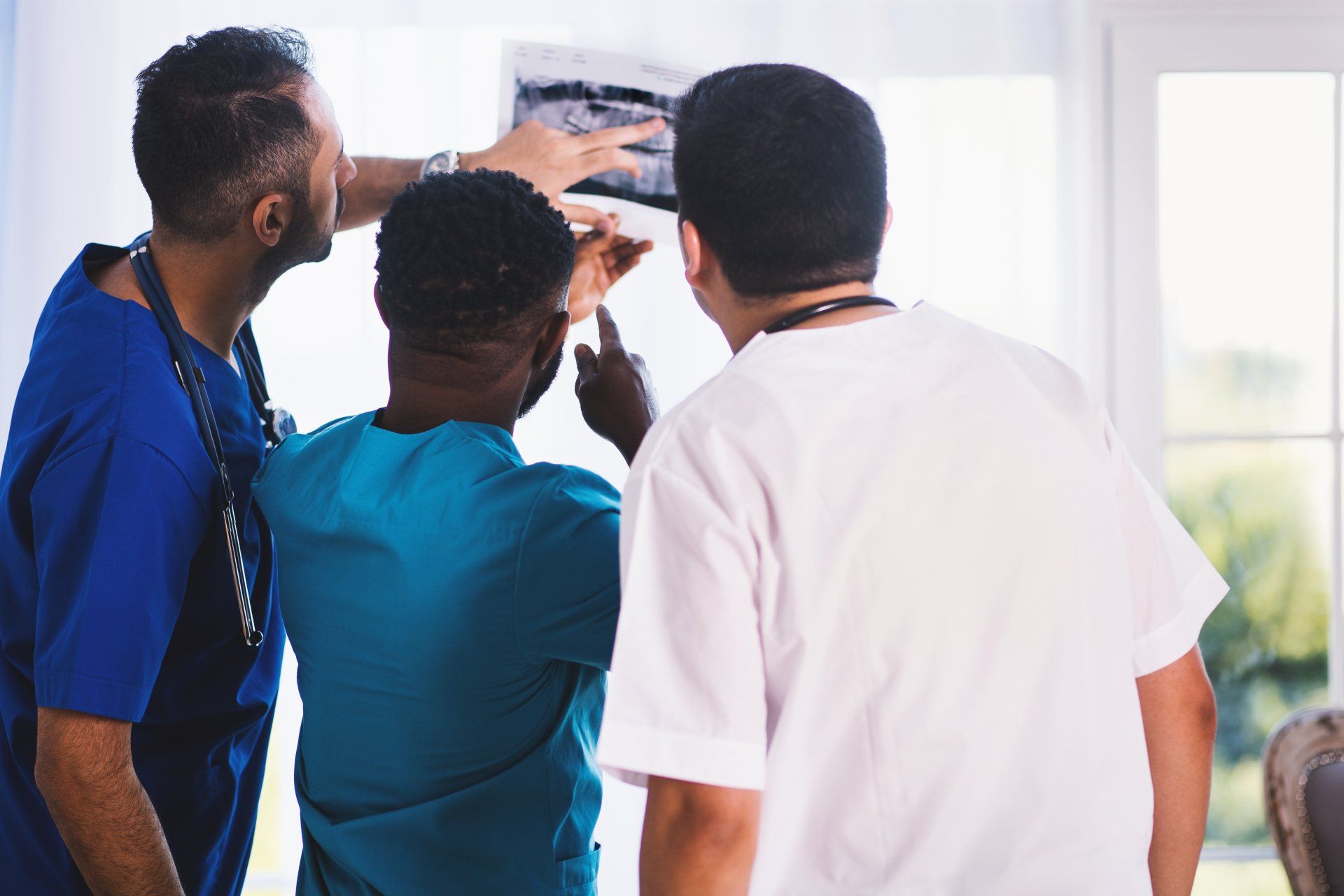 A group of doctors and nurses are looking at an x-ray.