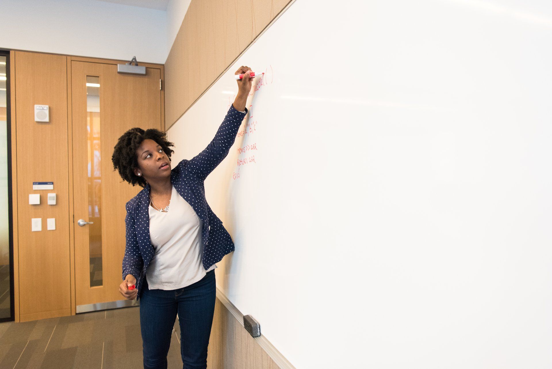 A teacher writes on a blackboard