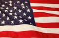 Waving American flag with red and white stripes and a blue field of white stars